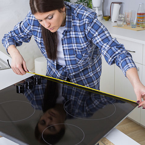 woman installing cooktop in kitchen
