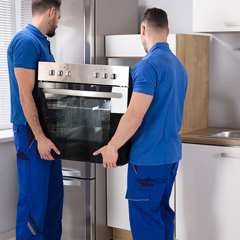 men installing oven appliance in kitchen